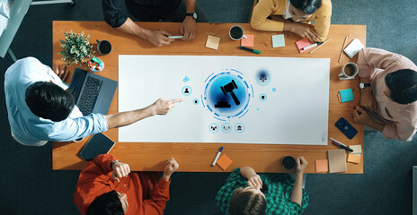 A diverse group of professionals engages in a collaborative meeting focused on digital technology and law, utilizing innovative tools in a vibrant office setting. Trope