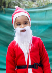 festive christmas portrait of toddler wearing santa outfit