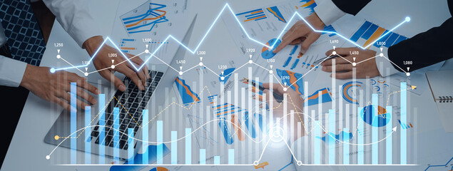 Professionals collaborate over various charts and graphs in a modern office setting, analyzing data and insights to drive strategic business decisions and enhance performance. Scalp