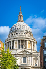 A vertical, low-angle view of the iconic lead-covered dome of St. Paul&rsquo;s Cathedral set against a clear blue summer sky in London