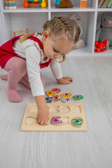 little girl playing with a wooden educational number puzzle toy