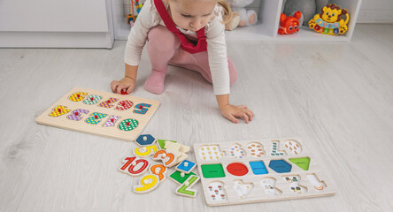 little girl playing with a wooden educational number puzzle toy