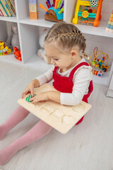 little girl playing with a wooden educational number puzzle toy