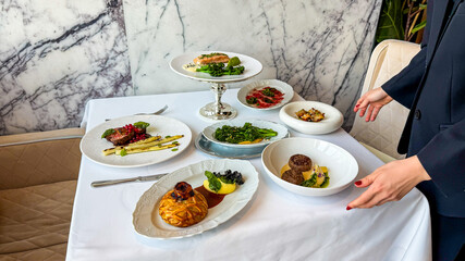 Marbled elegance meets culinary artistry as a Caucasian woman presents gourmet delights, capturing the essence of Restaurant Week