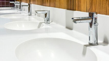 Sleek chrome taps glisten on pristine sinks, evoking minimalist zen aesthetics, World Plumbing Day...