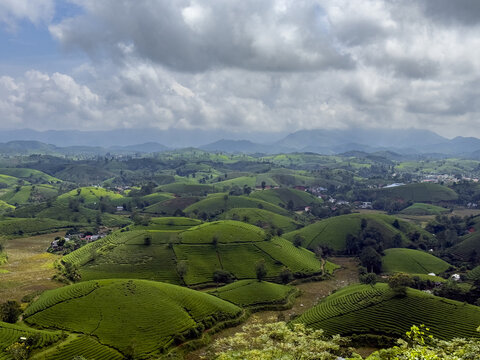 View of verdant green hills cascade under a sky streaked with dramatic clouds, creating a serene yet vibrant landscape, Phu Tho, Ph&uacute; Thọ, Vietnam.
