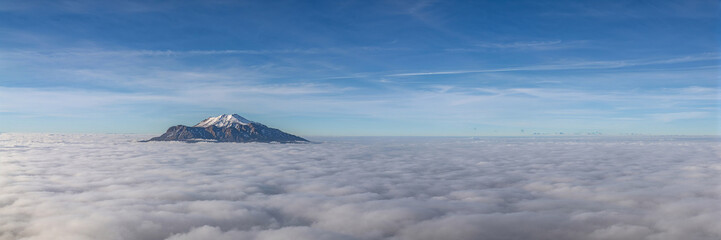 Obraz premium Calm sea with distant island beneath soft clouds