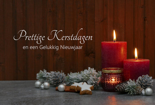 Kerstkaart: Harmonieuze kerstversiering met rode kaarsen, kerstversieringen en dennentakken. Op de achtergrond staat de Nederlandse tekst "Prettige Kerstdagen en een Gelukkig Nieuwjaar".