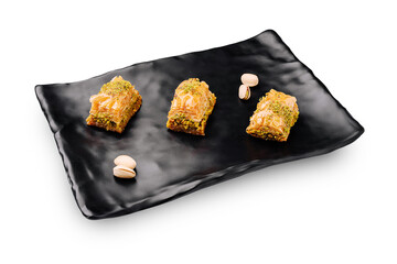 Delicious baklava served on a stylish black plate with pistachios