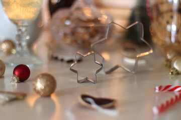 Cookie jar, tea, wine, nuts, books, lit candles and Christmas decorations on the table. Cozy Christmas hygge at home. Selective focus.