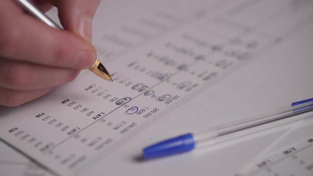 Hand Marking Payroll Numbers On Form, Clerk Circling Salary Values And Deductions With Pen, Ballpoint Nearby On Pale Sheet, Careful Tallying Of Wages And Taxes, Routine Payroll Duty