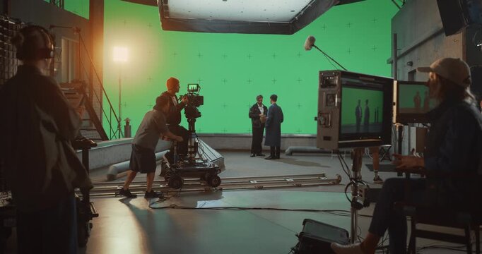 Professional Film Crew Actively Shoots a Dialogue Scene on a Soundstage, Operating Camera Dolly,  Actors Perform Before a Large Green Screen, Cinematic Footage of High-end Movie Production.