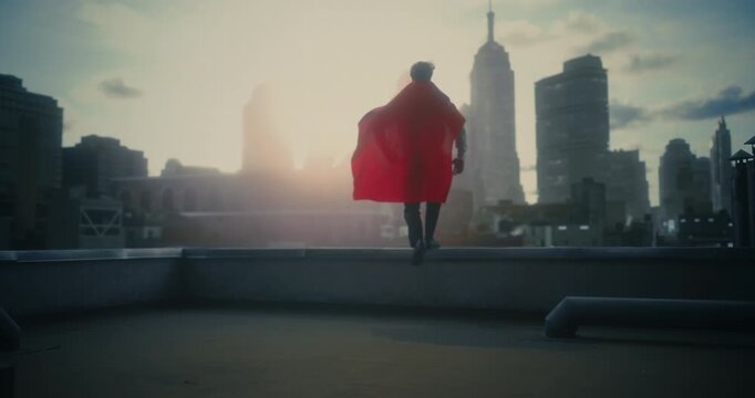 A Young White Male Superhero in a Flowing Red Cape Walks Across a Rooftop Dramatically Overlooks a Futuristic City Ready to Fight Crime. Cinematic Conceptual Mock-up Movie, Trailer Scene