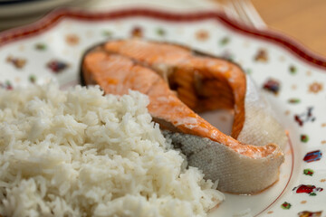 Close-up of a delicious steamed salmon steak with a side of fluffy white rice. A healthy homemade...