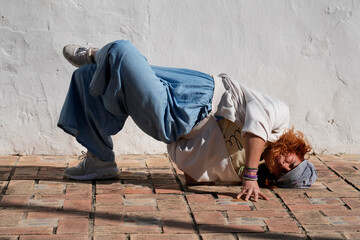 Young woman performing urban acrobatics street dance
