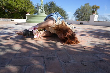 Woman practicing yoga outdoors with hibiscus flowers