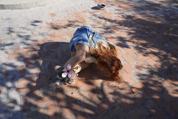 Woman practicing yoga outdoors with hibiscus flowers