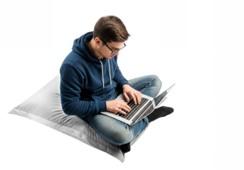 Young man using laptop in casual relaxed pose on pillow in soft natural lighting for lifestyle advertising isolated on white background