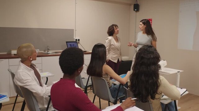 Female speaker presenting a seminar to students in a classroom