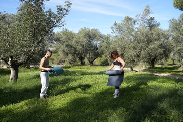 Couple preparing yoga mats for outdoor exercise