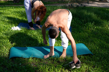 Couple preparing yoga mats for outdoor exercise