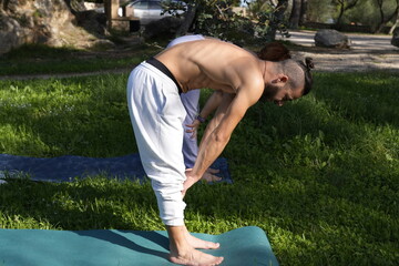 Couple preparing yoga mats for outdoor exercise