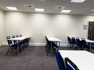 Bright university conference room with white tables and blue chairs in Manchester UK for meetings and events