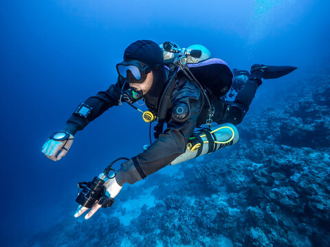 lateral view of a technical diver in backmount configuration in the blue 