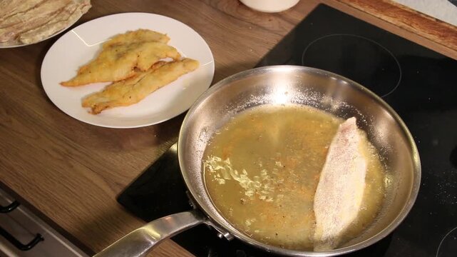 putting unbaked hake fish in oil