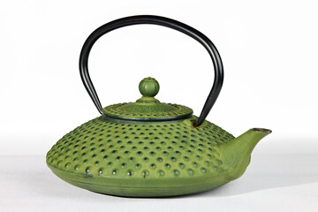 A vibrant green cast iron Japanese teapot (tetsubin) with a textured surface and black handle, presented on a clean white background.
