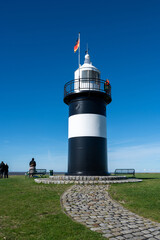 The small lighthouse in Wremen on the North Sea coast is open to visitors, with a footpath and a blue sky