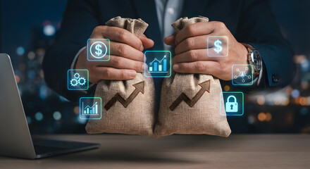 Businessman Holding Money Bags with Digital Financial Growth Icons on Screen