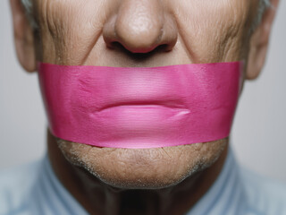 Freedom of speech censored - white middle aged man's mouth closed with pink tape