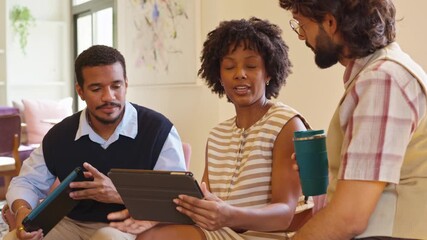 Diverse creative team collaborating using a digital tablet