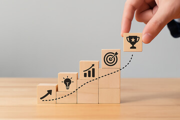Hand Placing Trophy Icon on Wooden Blocks Staircase Representing Business Growth and Goal Achievement