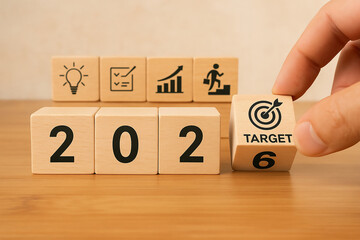 2026 business goals and strategy. Hand flipping wooden blocks with target icon, planning and KPI concept