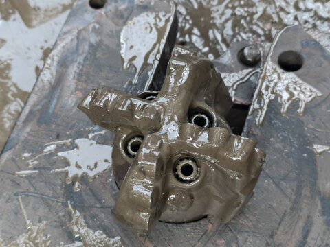 Polycrystalline Diamond Compact (PDC) drilling bit on the rig floor used for drill oil and gas well for petroleum exploration and production.
