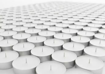 Fototapeta premium Numerous unlit white tea light candles arranged in precise rows extending into the distance