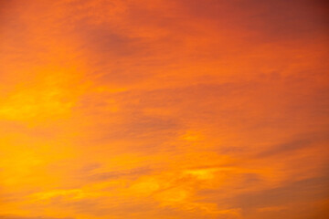 Colorful sunset sky with warm orange and purple clouds creating a dramatic natural background. Soft gradient evening light for nature, travel, landscape and abstract design use, beautiful dark sky