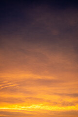 Colorful sunset sky with warm orange and purple clouds creating a dramatic natural background. Soft gradient evening light for nature, travel, landscape and abstract design use, beautiful dark sky