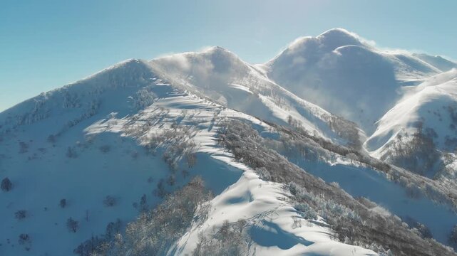 Aerial fly Peak of Mount Iwaki, Japan winter snow, Ski Resort Mountain Backdrop