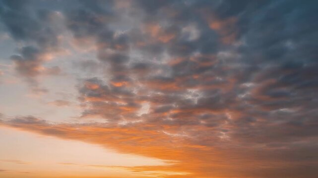 Dramatic sky with dark clouds tinged with pink and orange light during sunset.