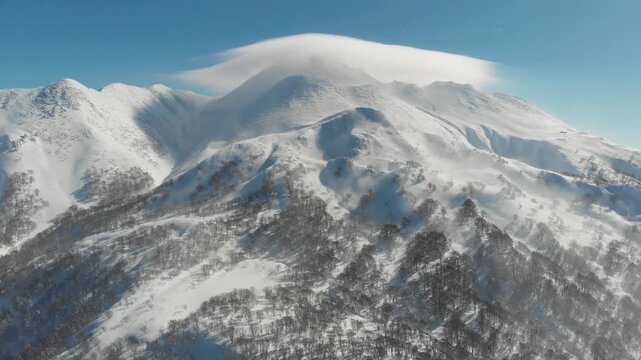 Drone fly top of Mount Iwaki in Aomori Japan, snowed mountain in blue skyline daylight, Japanese winter landscape