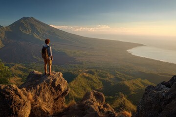 Fototapeta premium Active travel scene: solitary hiker on elevated rock with dramatic Bali mountain panorama