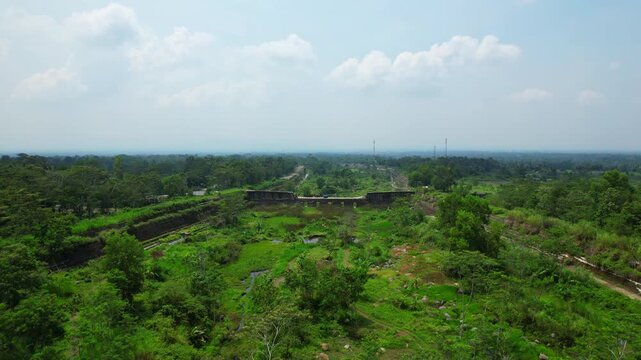 Aerial drone footage of a tropical covered with vegetation, evacuation canal in Java island, Indonesia, that is suppose to guide lava when the volcano is erupting