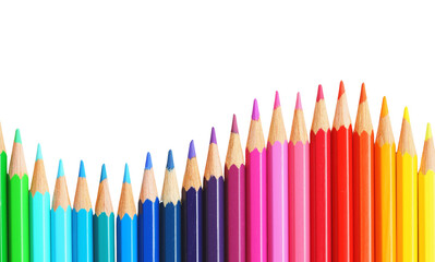 Colorful pencils arranged in a vibrant spectrum on a white background viewed from a straightforward angle