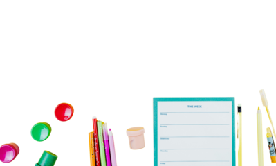 Stationery and colorful objects arranged on a white background viewed from directly above