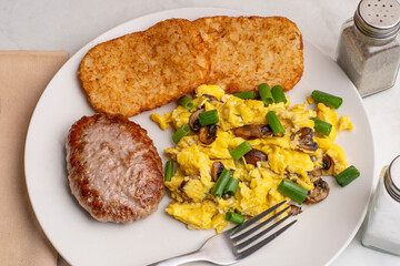 scramble eggs with sausage patty and hash browns