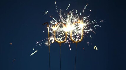 Number 100 anniversary celebration festive footage made with Bengal fire in the form of number Hundred on dark blue background