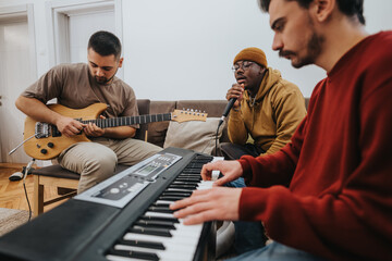 Three friends play music together in a cozy living room, with guitar, keyboard, and microphone. A casual jam session among friends captures creativity and collaboration.